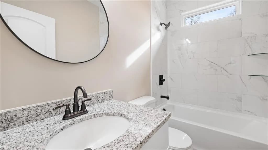 Primary bathroom with granite vanity and marble tile shower