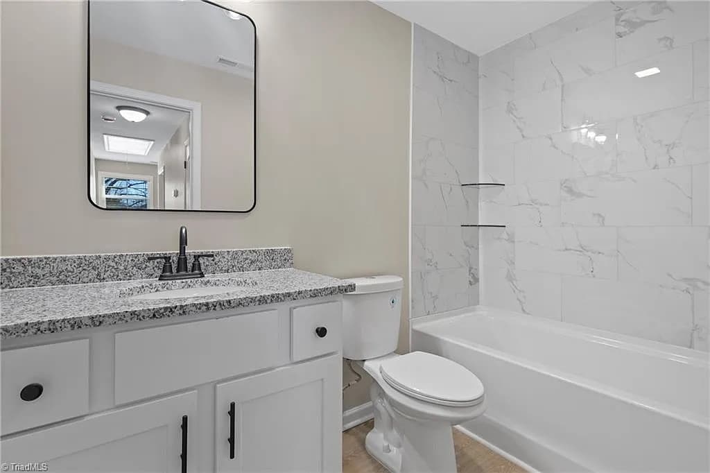 Bathroom with granite vanity and marble tile shower