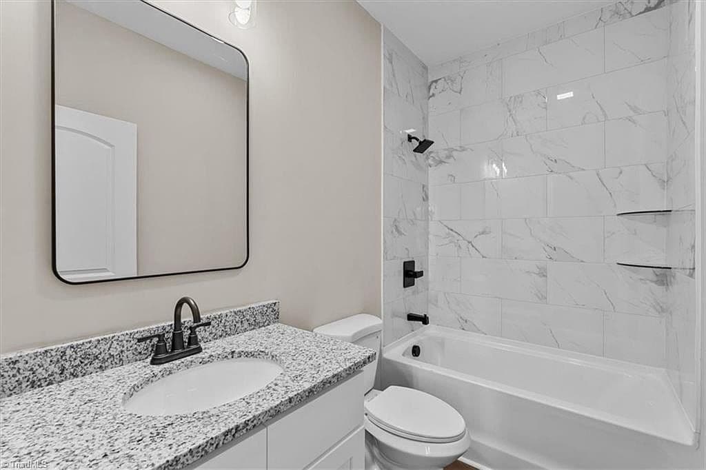 Bathroom with marble tile shower and granite vanity