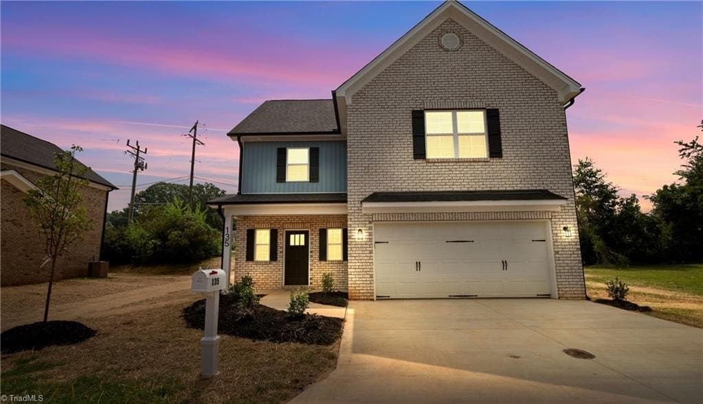 Brick new construction front elevation at dusk